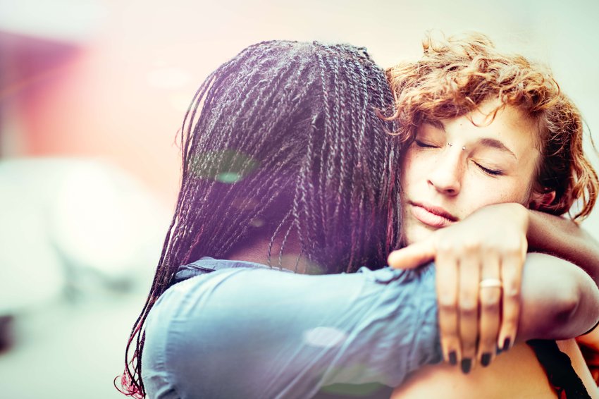 Afrikanische Frau, die im Freien ihre kaukasische Freundin unterstützt.