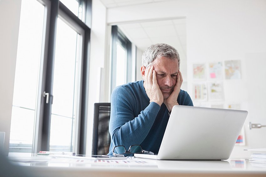 Mann, der auf einen Laptop-Bildschirm starrt